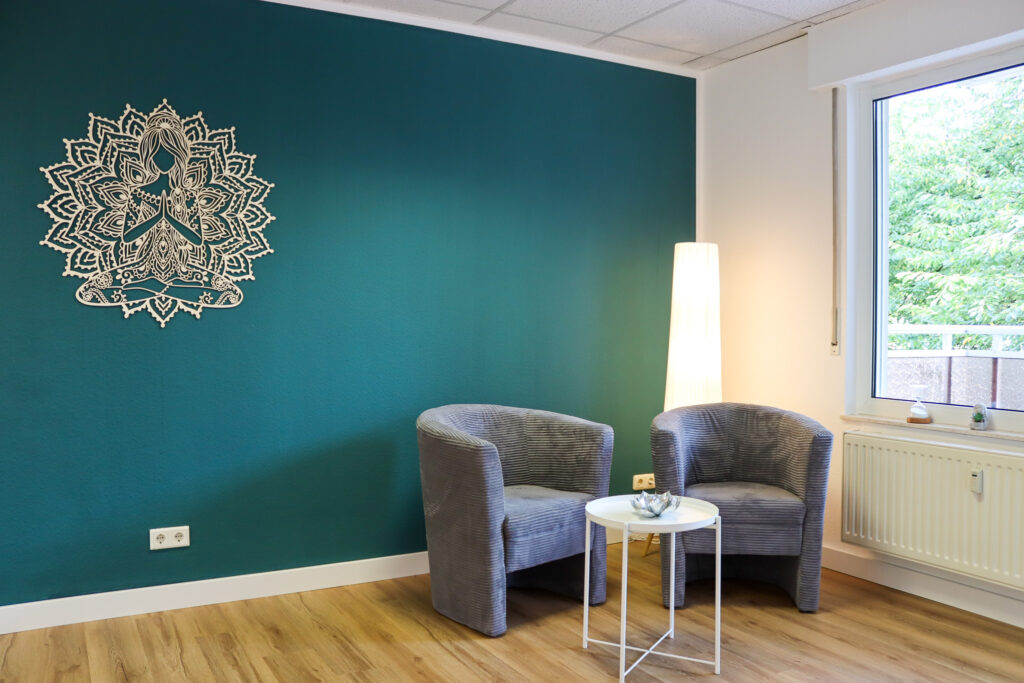 Eine Sitzecke im VAYANA-Yoga-Studio mit zwei Sesseln und einem Tisch.