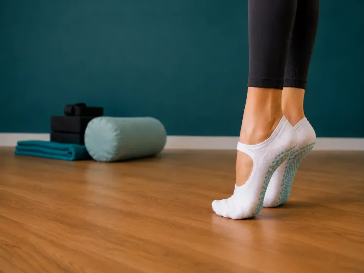Eine Frau steht auf Zehenspitzen im VAYANA-Yoga-Studio.